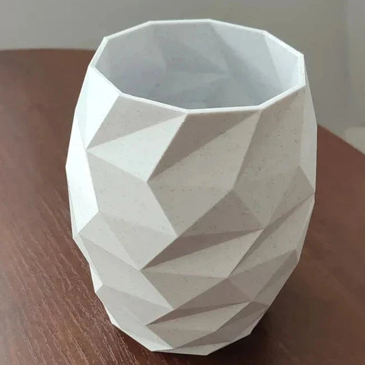White geometric-patterned vase on a wooden surface